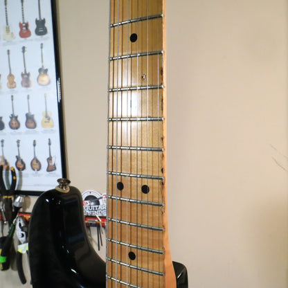 Fretboard view alongside a reference poster in a workshop setting