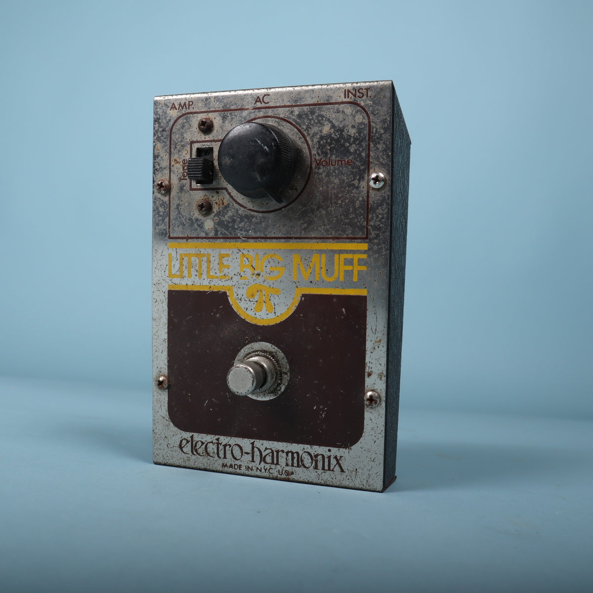 Angled front view showing the volume knob, tone switch, and footswitch.