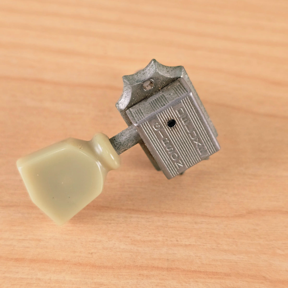 Elevated angled view of the nickel Gibson Deluxe tuner body and button.