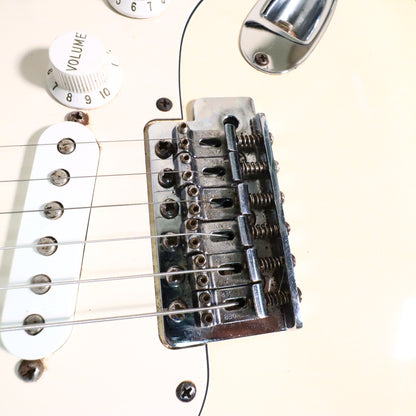 Close-up of Fender stamped tremolo bridge saddles and bridge pickup