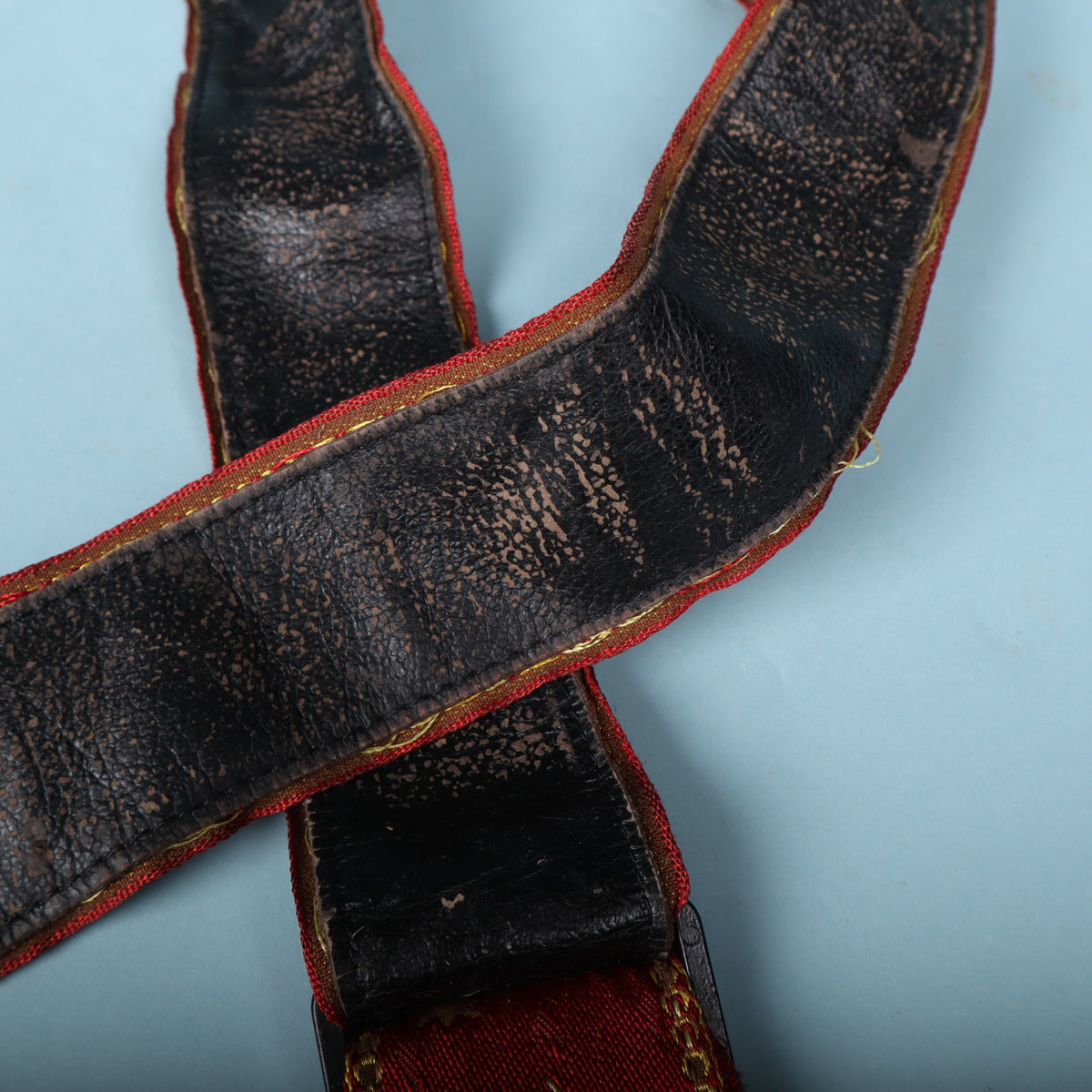 Close-up of heavy finish flaking on the black strap backing