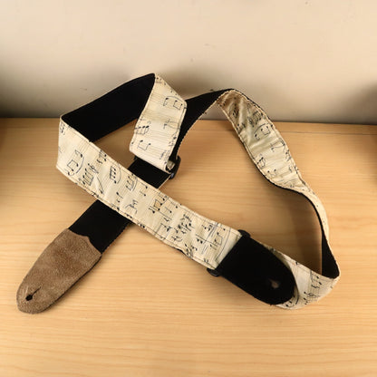 Guitar strap showing black webbing backing and tan suede leather end.