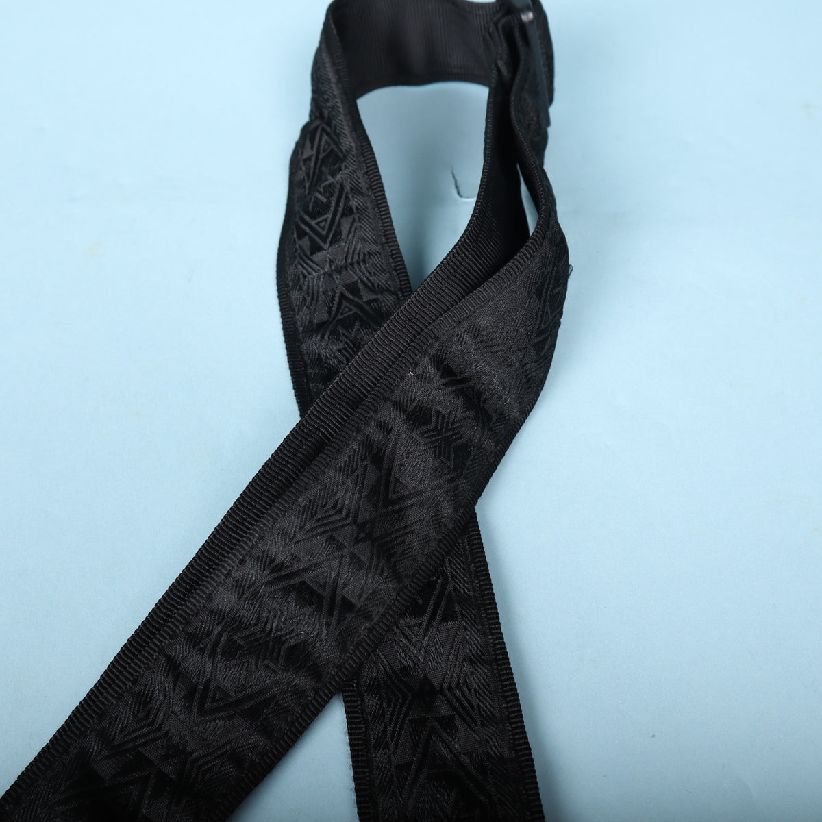 Angled view of the woven strap body showing pattern texture and tubular webbing edge.