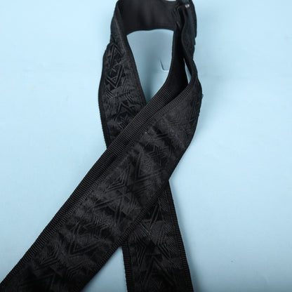 Angled view of the woven strap body showing pattern texture and tubular webbing edge.