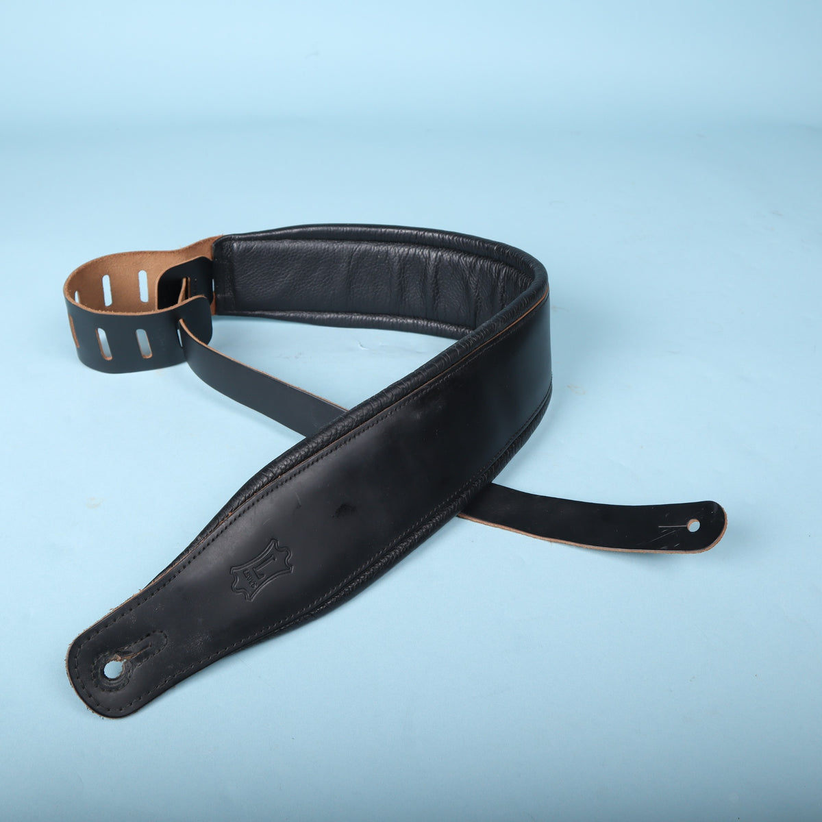 Levy's black padded bass strap showing embossed logo and end pin hole detail.