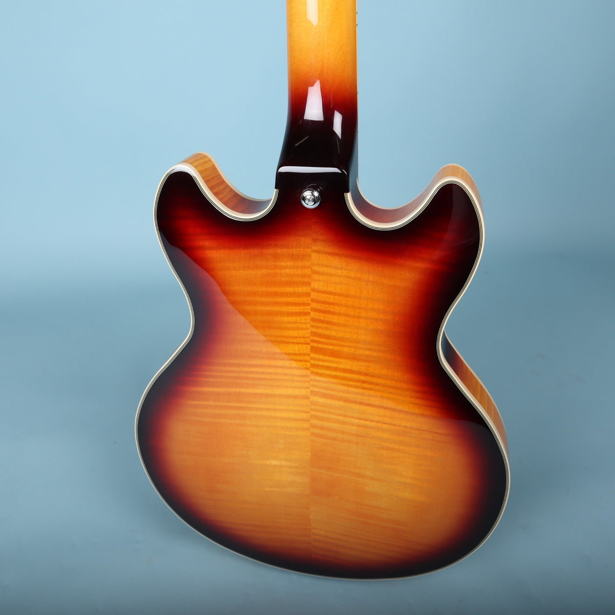 Angled view of the flame maple back and neck heel of the Premier Mini DC guitar.