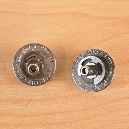Close-up top view of the stamped text on both Jim Dunlop Original Straplok mechanisms.