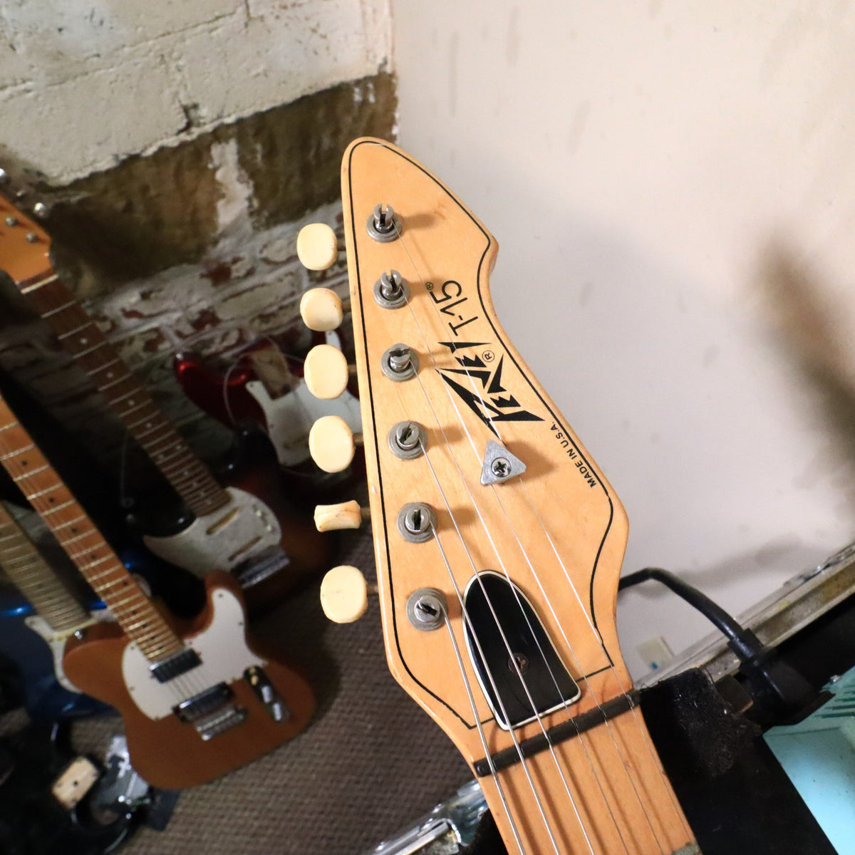 Peavey T-15 headstock front resting on a work bench.