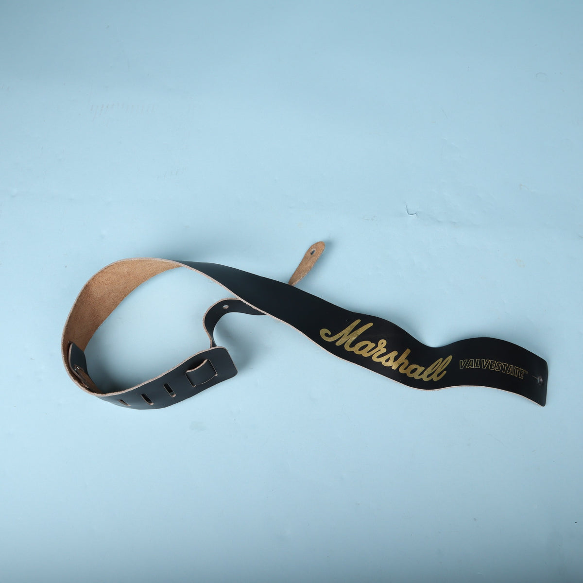 Angled view of the coiled Marshall Valvestate guitar strap showing both ends