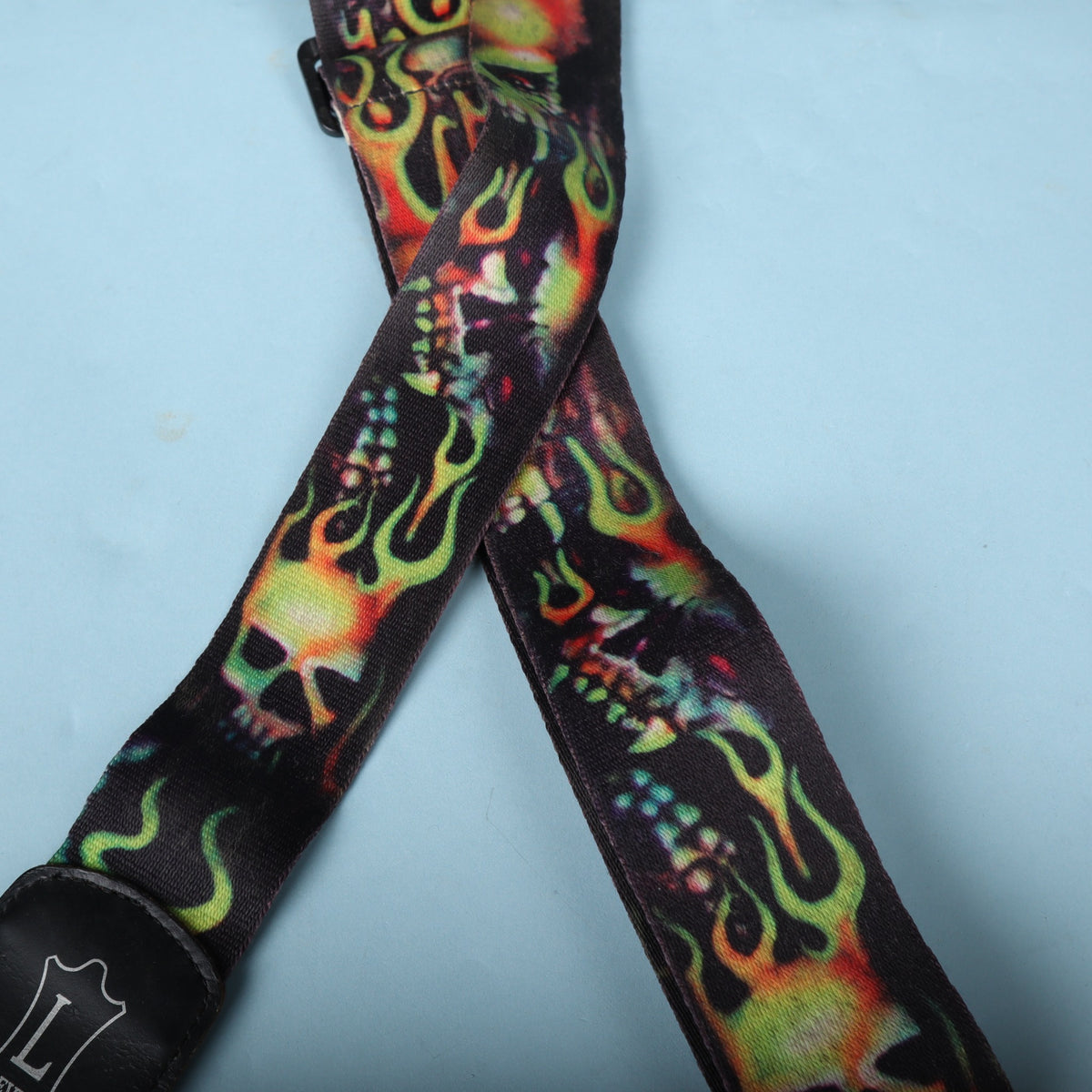 Detail of the colorful printed skulls and flames across the black strap webbing.