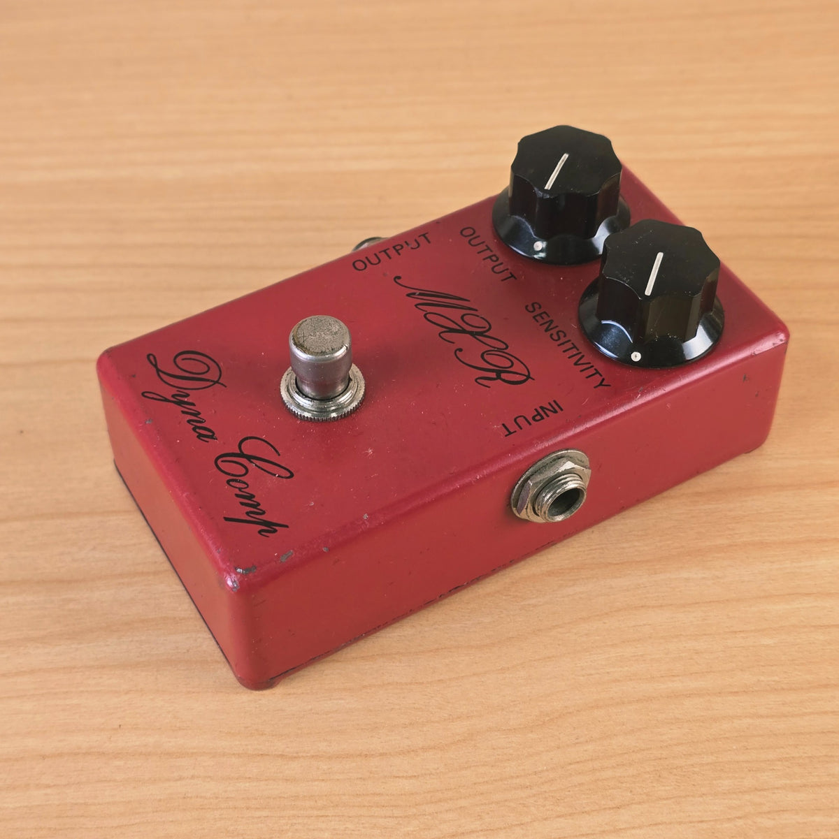 Angled top-down view showing the right side input jack, knobs, and footswitch on the MXR Dyna Comp.