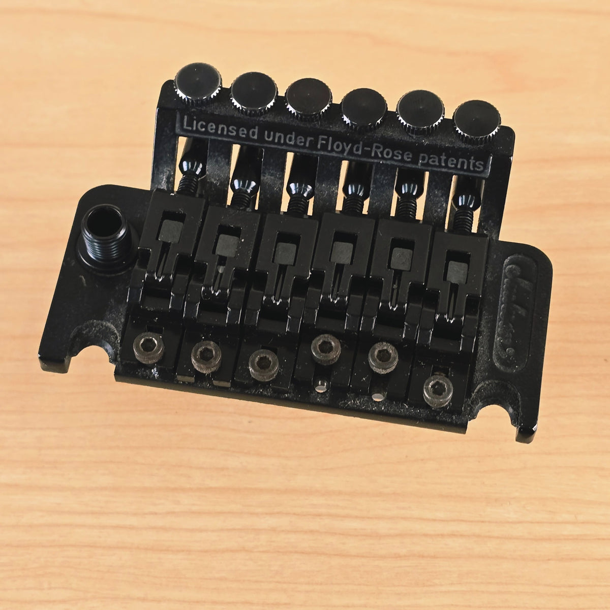 Top-down view of the black Jackson licensed Floyd Rose tremolo bridge.