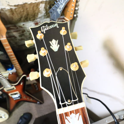 Headstock close-up showing gold tuner posts and truss rod cover.