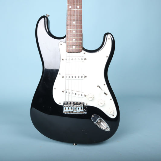 Front view of black Stratocaster body with white pickguard and three single-coil pickups.