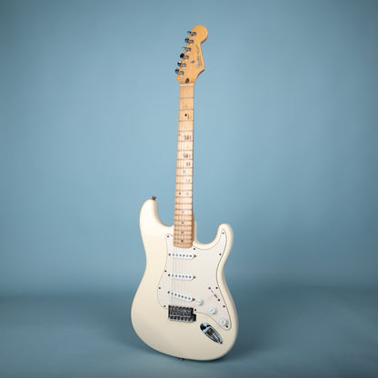 Full front view of white Fender Stratocaster on blue studio background