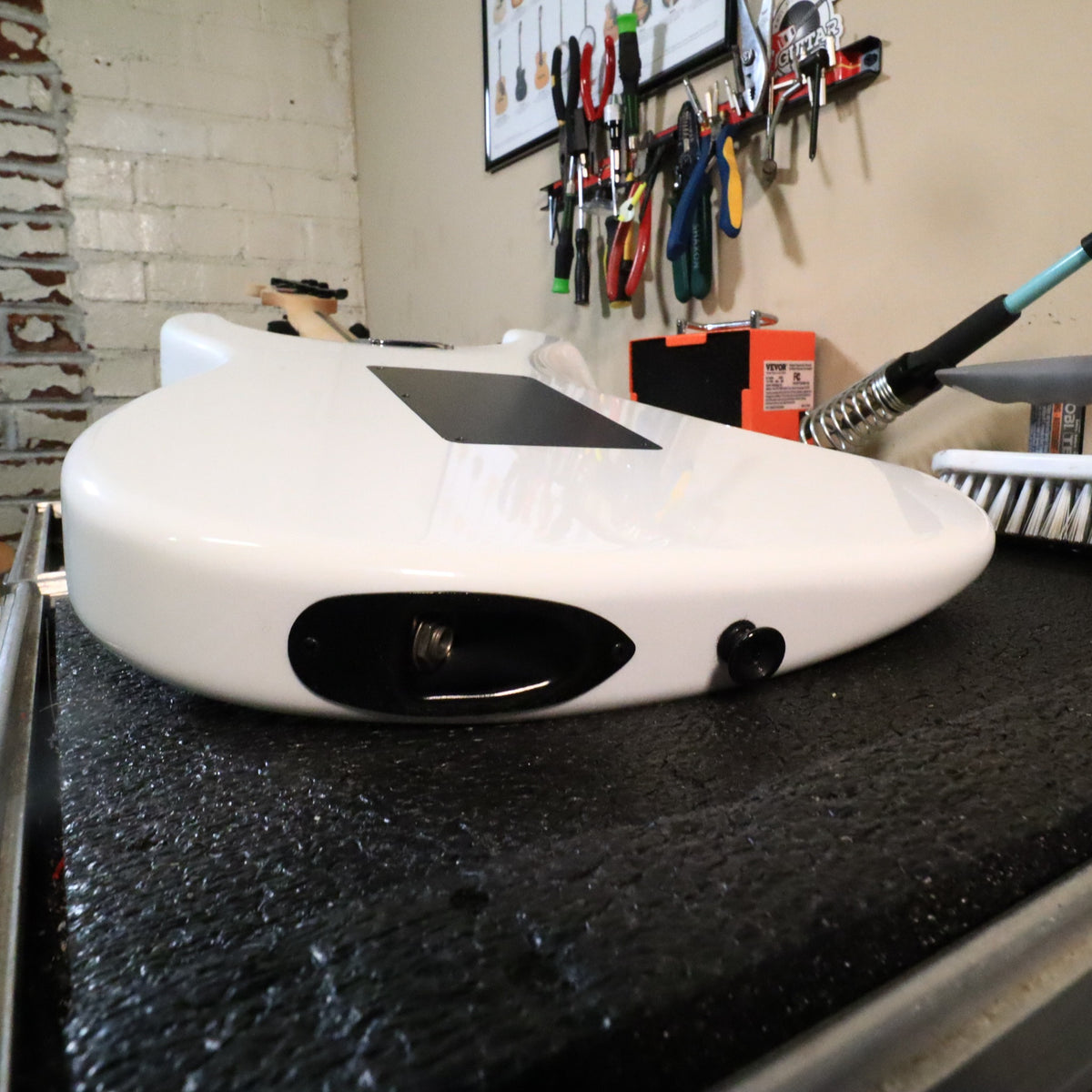 Rear body view resting on tech bench showing black backplate.