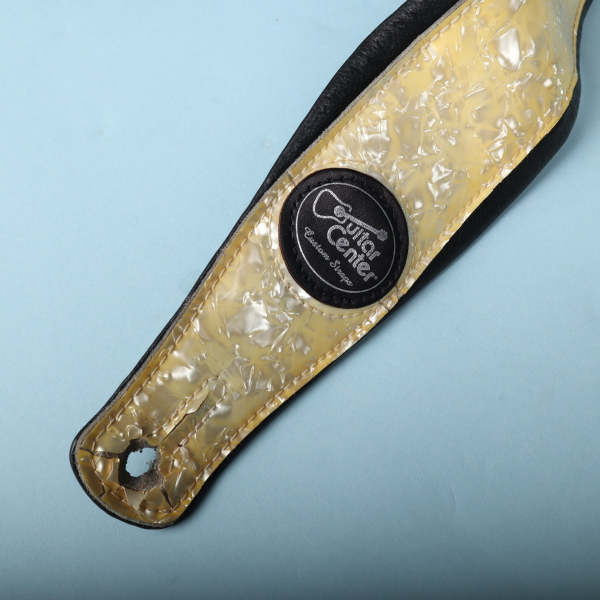 Close-up of the front end featuring the round Guitar Center Custom Straps leather badge.