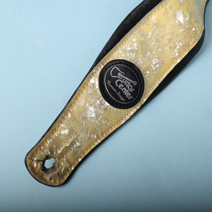 Close-up of the front end featuring the round Guitar Center Custom Straps leather badge.