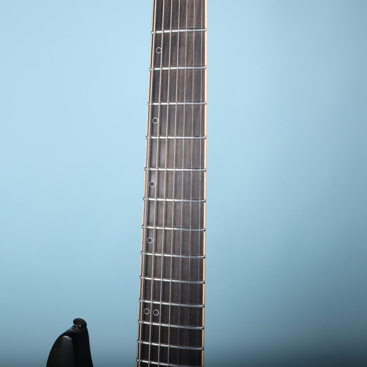 Close-up of the Schecter KM-7 MK-II ebony fretboard with offset ring markers and stainless frets
