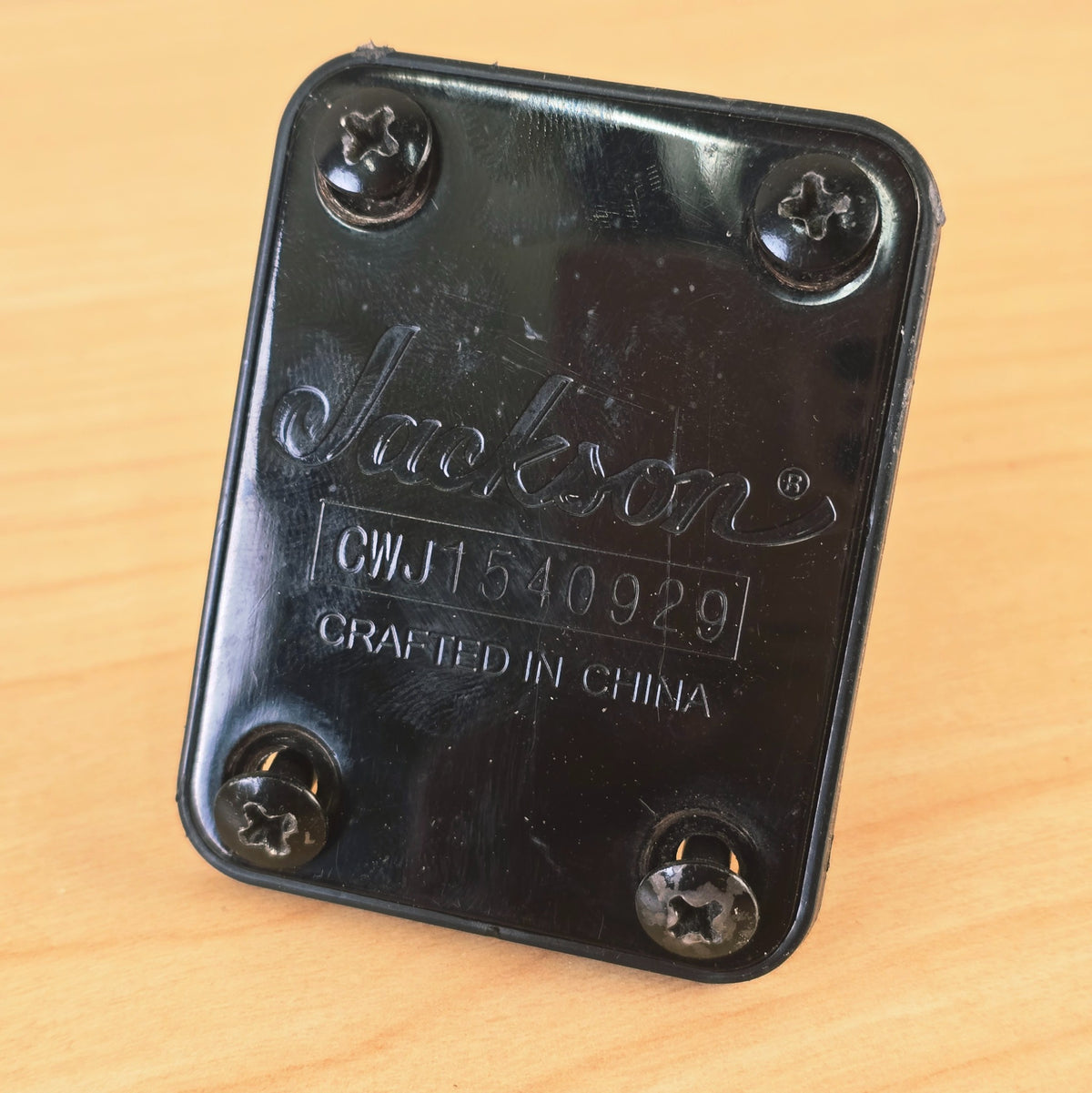 Front-facing angled view of the Jackson neck plate with all four screws attached