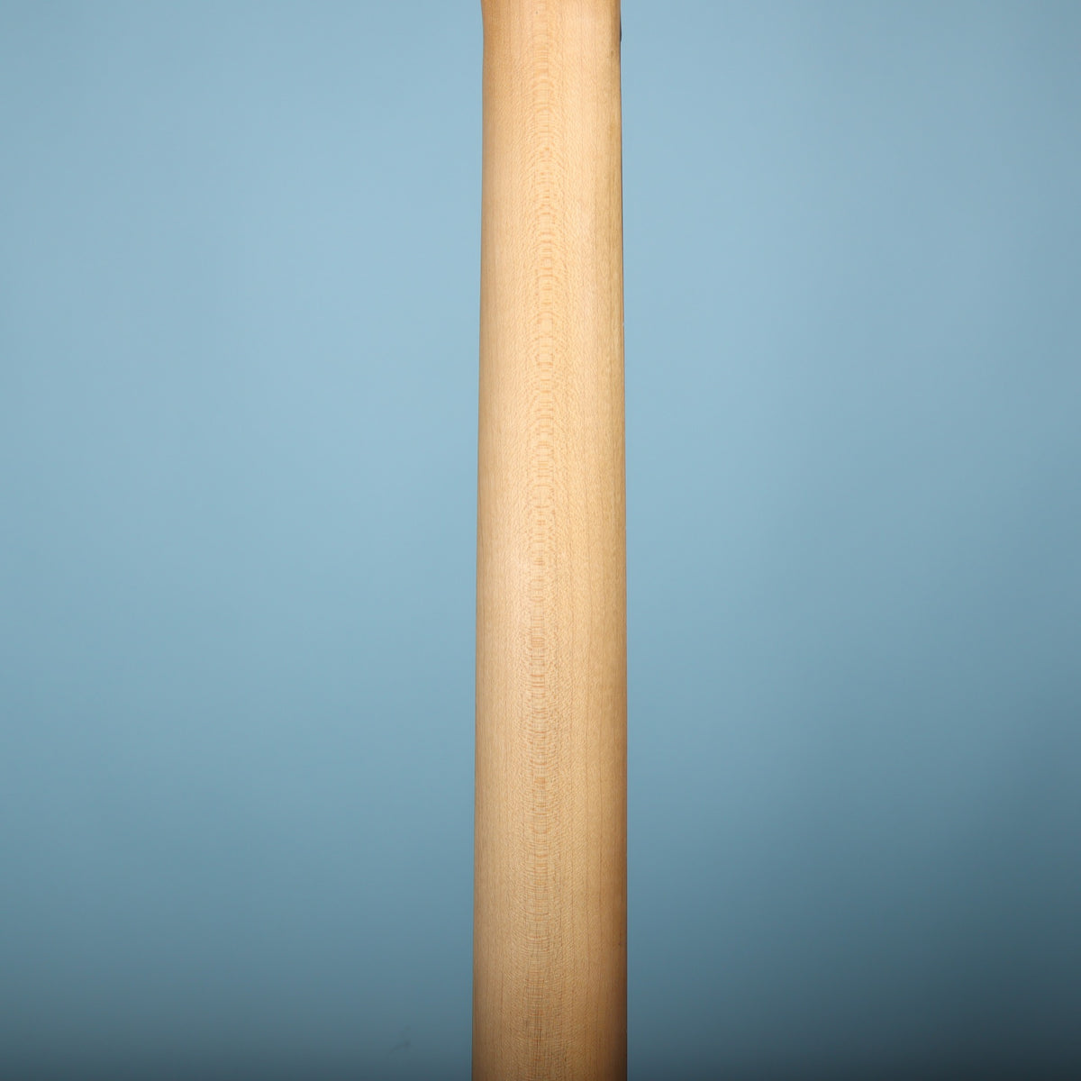 Rear view of smooth maple neck displaying light wood grain.