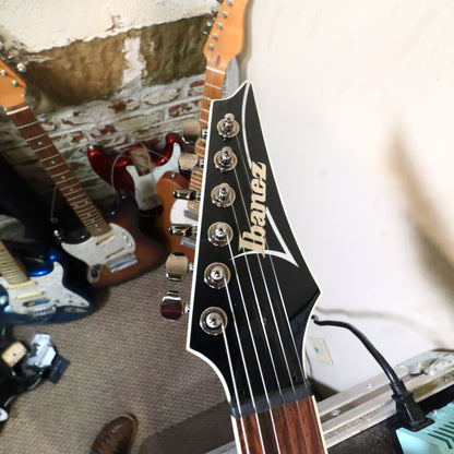 Headstock view on bench showing tuning machines and truss rod cover