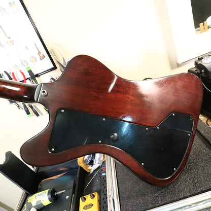 Back of the guitar body resting on a workbench showing finish condition and the large control cavity plate.