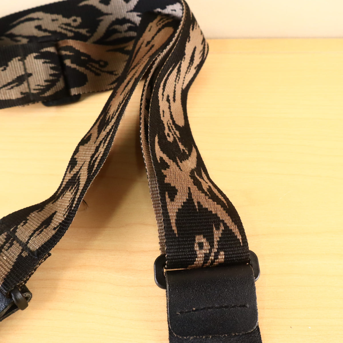 Detail of the woven webbing and stitched leather end attachment on the guitar strap.