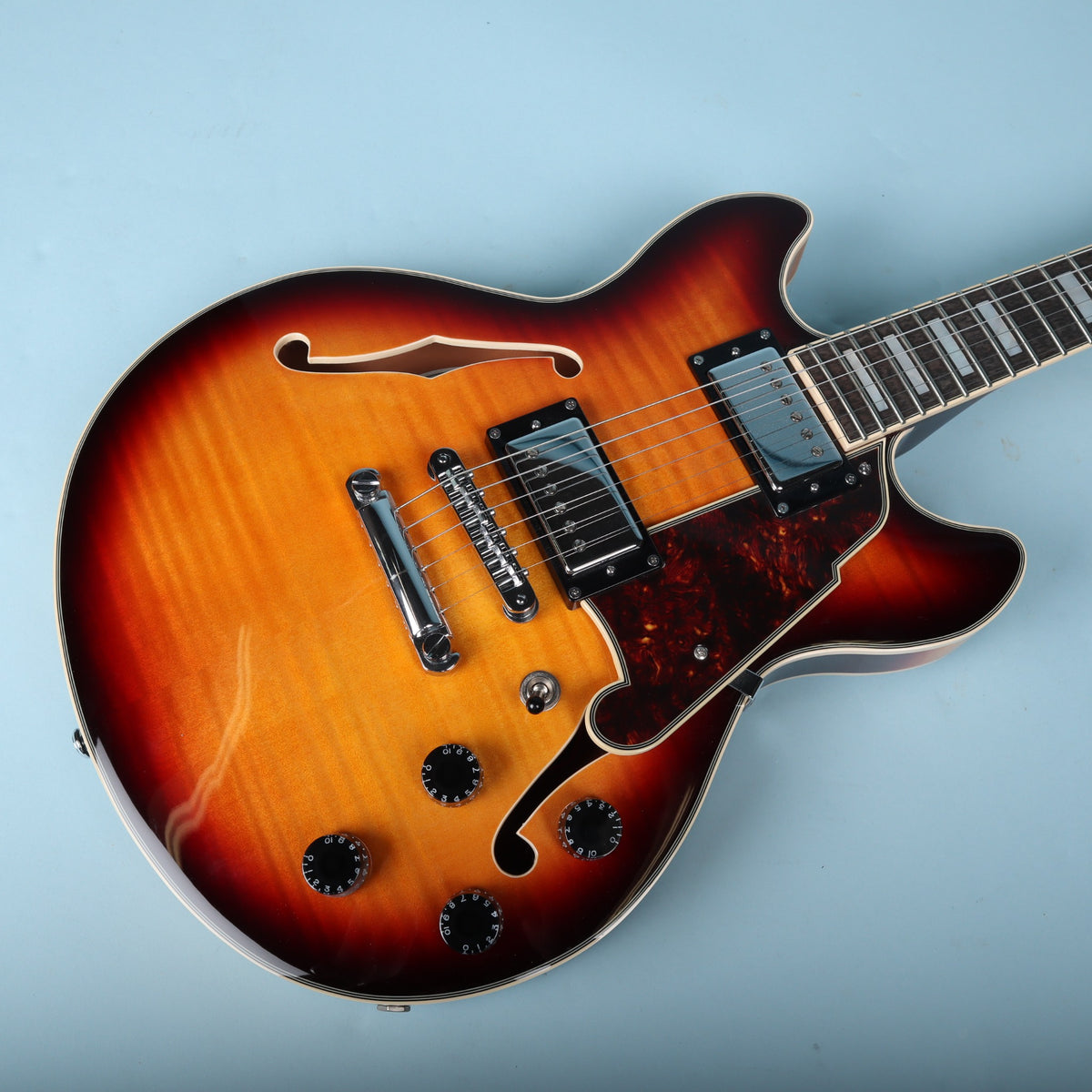Angled overhead view of the arched top, pickguard, and pickups on the Premier Mini DC.