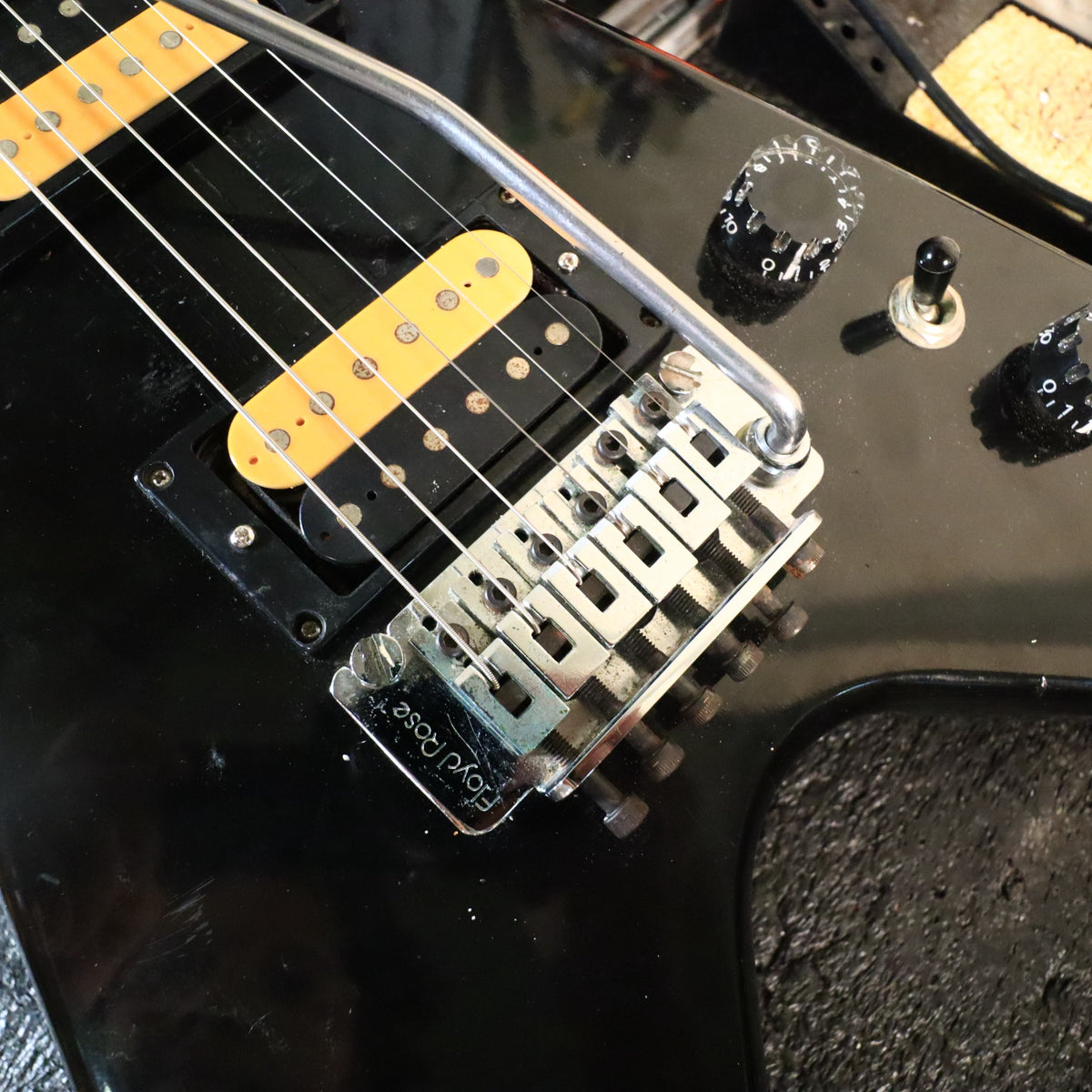 Floyd Rose tremolo bridge close-up with whammy bar attached.