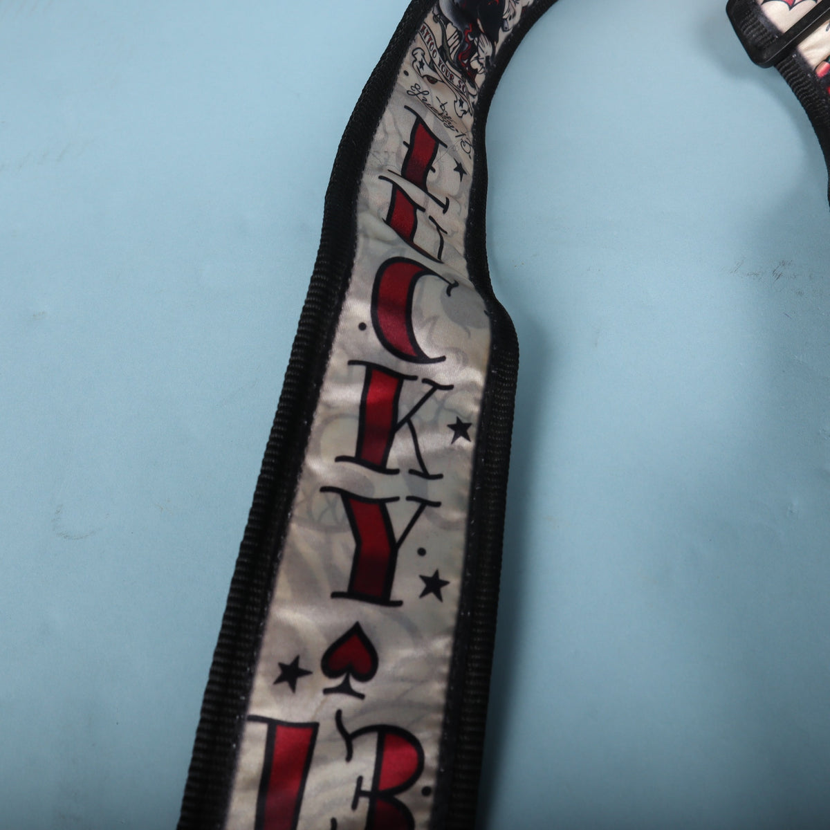 Close-up view of the vertical Lucky 13 text print along the strap ribbon