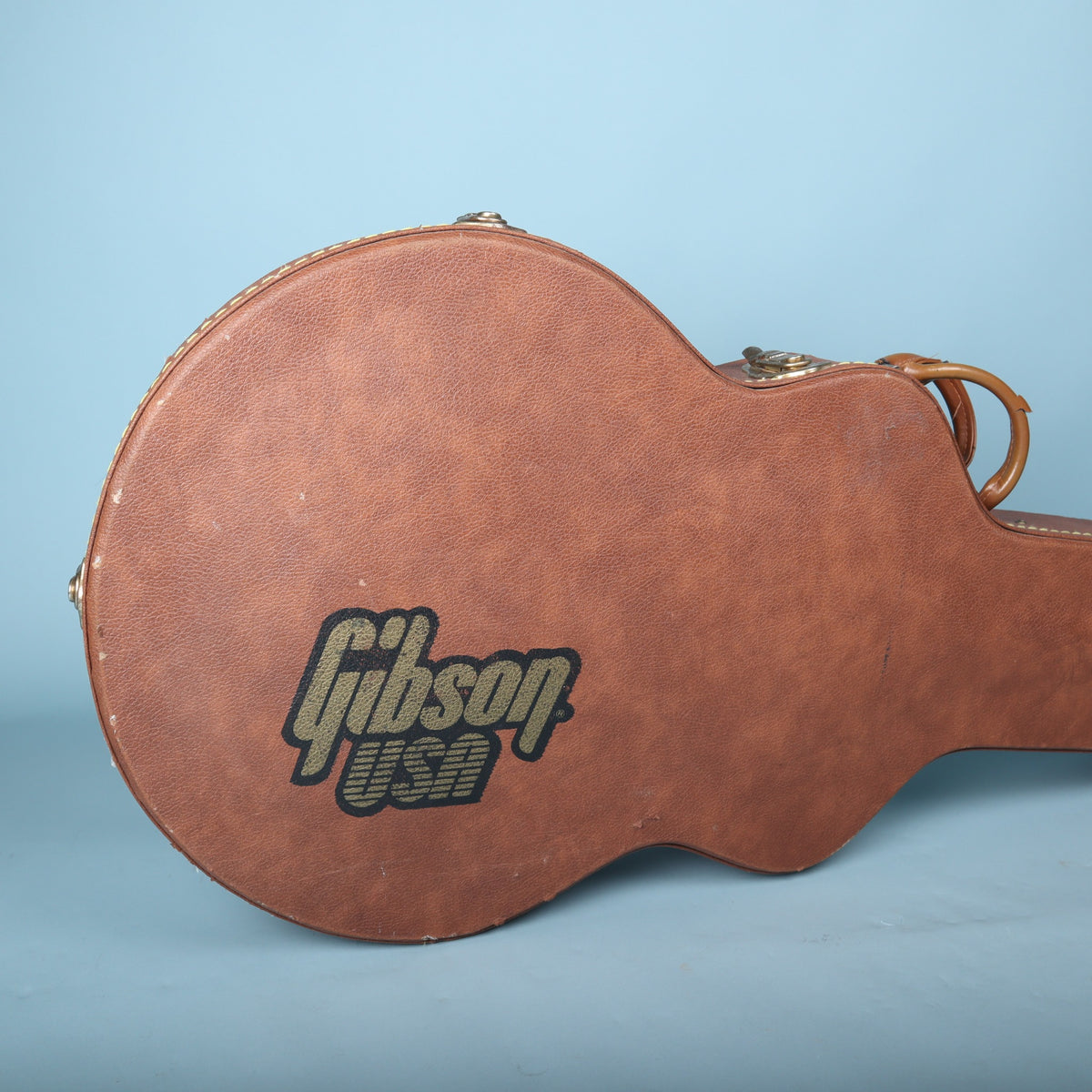 Close-up of the black and gold Gibson USA logo printed on the brown exterior