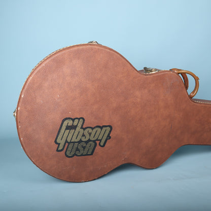 Close-up of the black and gold Gibson USA logo printed on the brown exterior