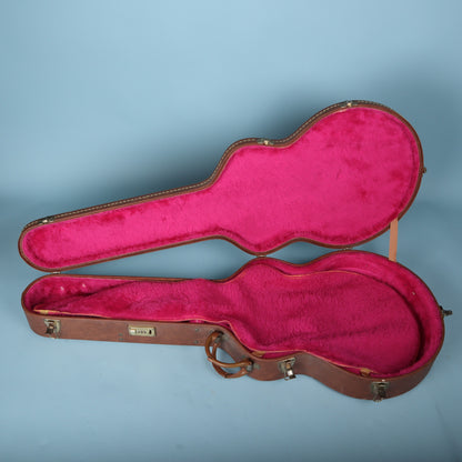 Open Gibson case showing the vibrant pink plush interior with the protective shroud resting on the upper lid