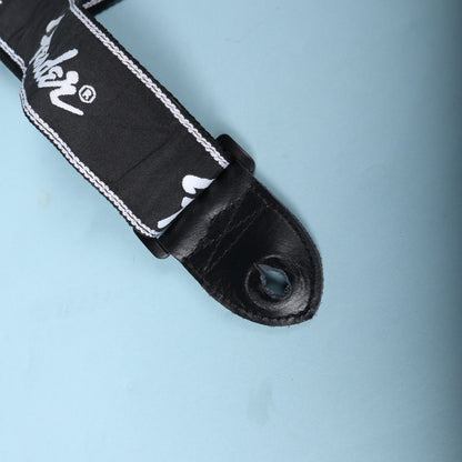 Detail of the buckle and leather end tab connection on a black Fender running logo strap
