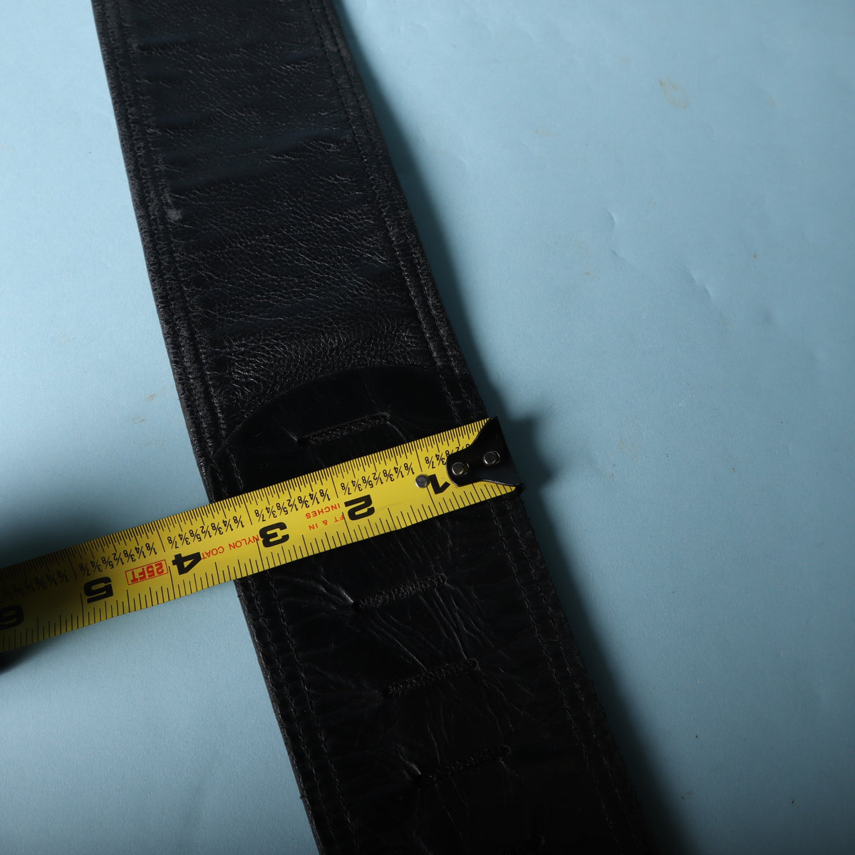 A tape measure showing the width of the padded strap section is approximately 3.5 inches.