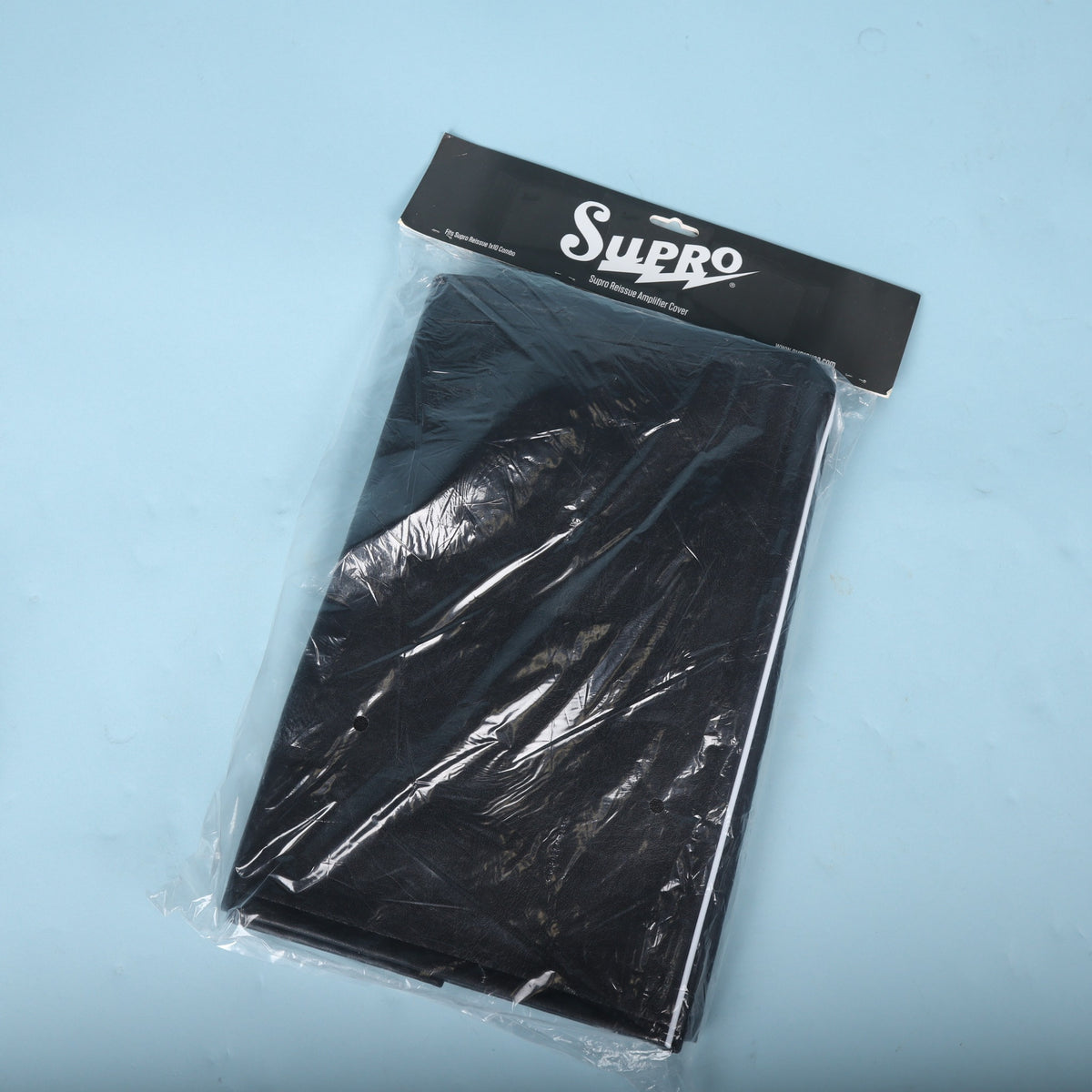 Rear view of packaged Supro Reissue amplifier cover showing folded back section.