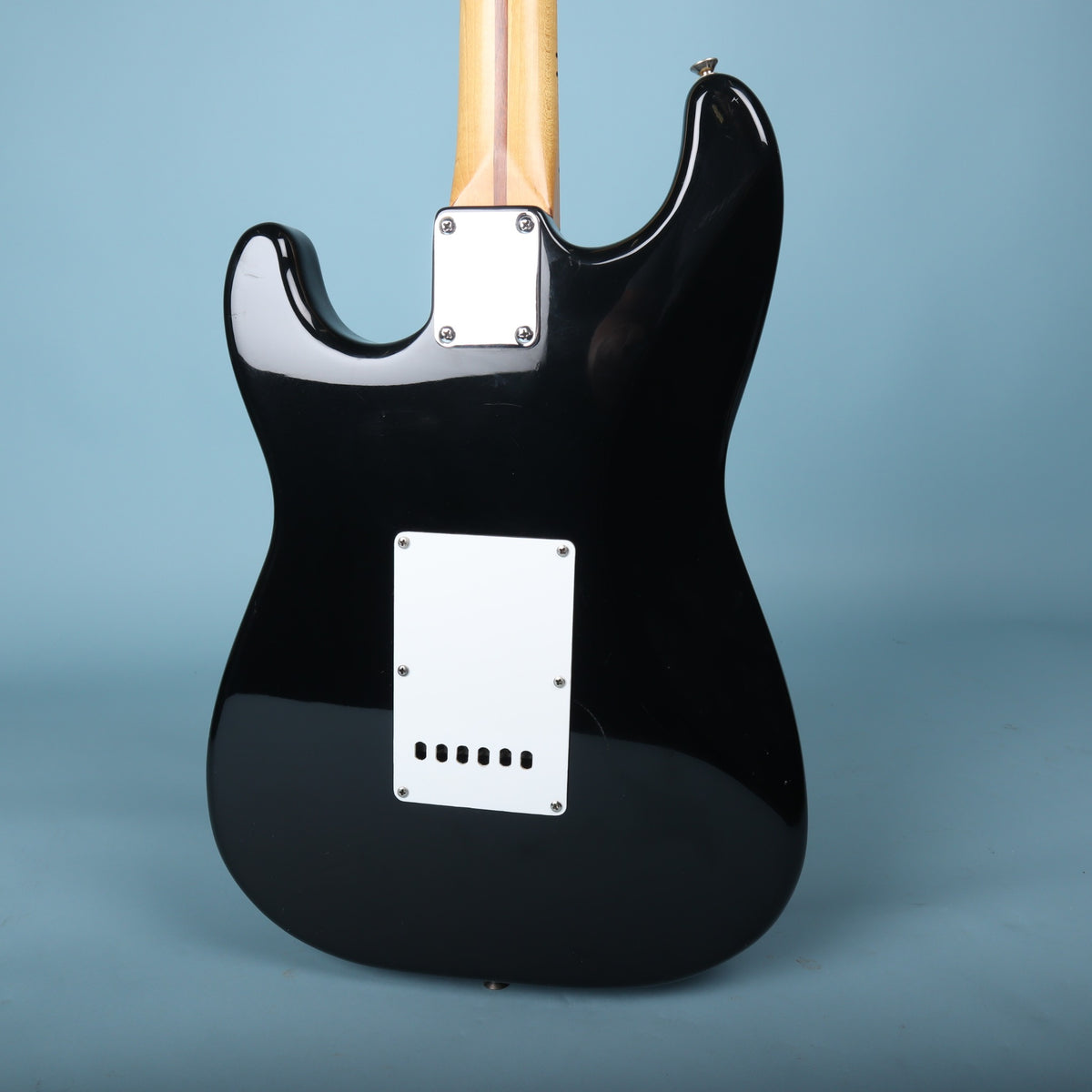 Back view of the black guitar body and neck plate