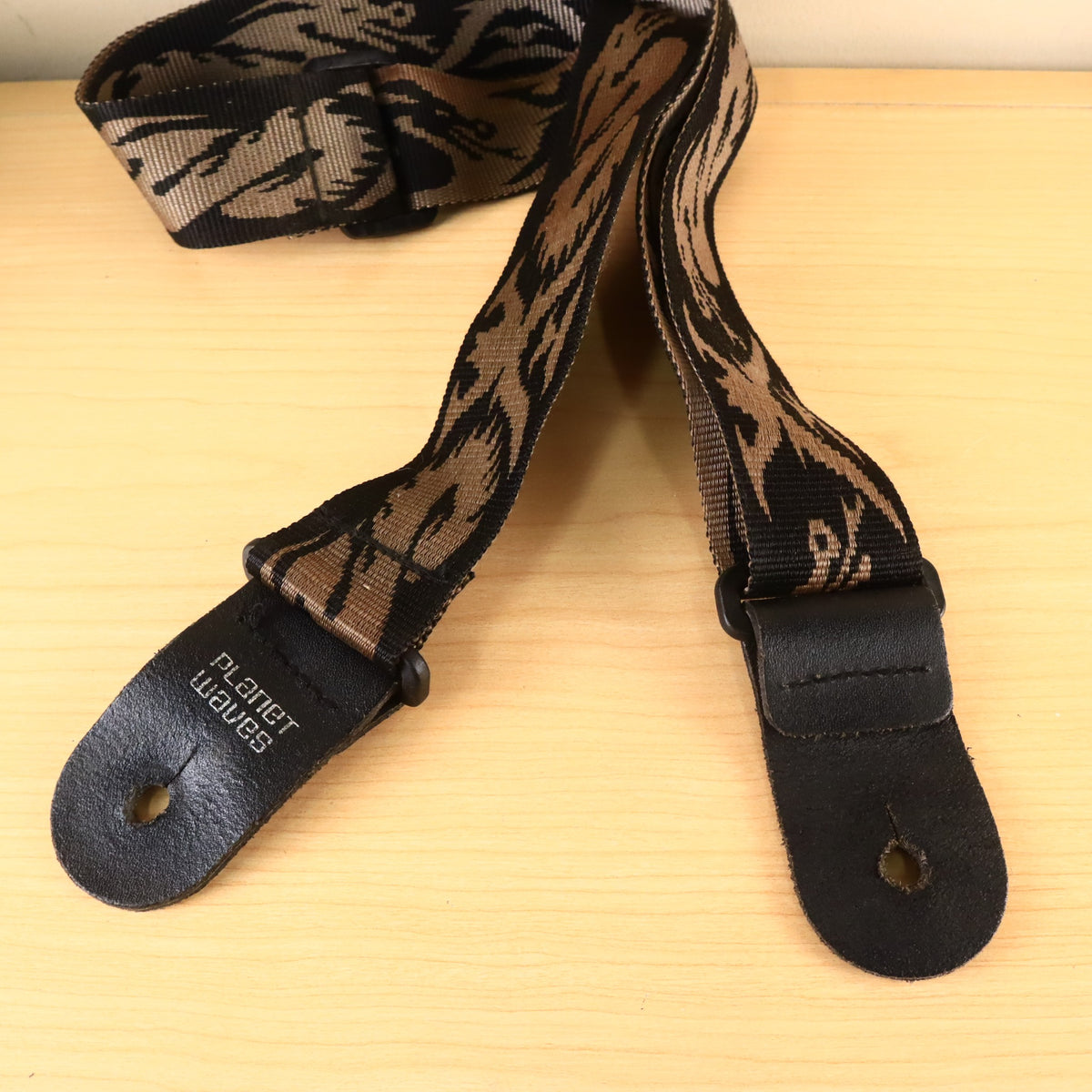 Detailed view of both black leather end tabs and the strap button mounting holes.
