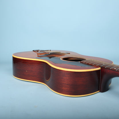 Angled side view of the Gibson B-25-12 body flat on a blue surface.