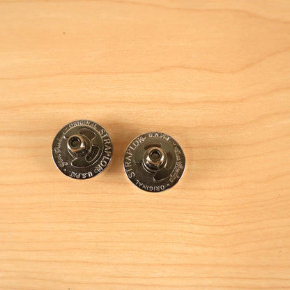Overhead view of two Jim Dunlop Original Straplok quick-release strap attachments.