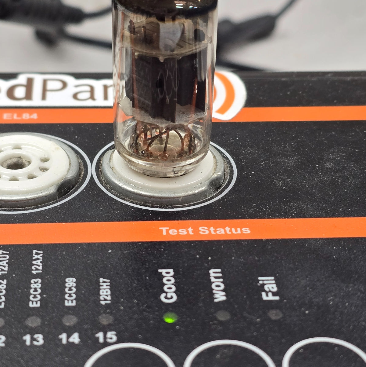 Close-up of tube tester panel with green Good light lit during 12AX7 test.