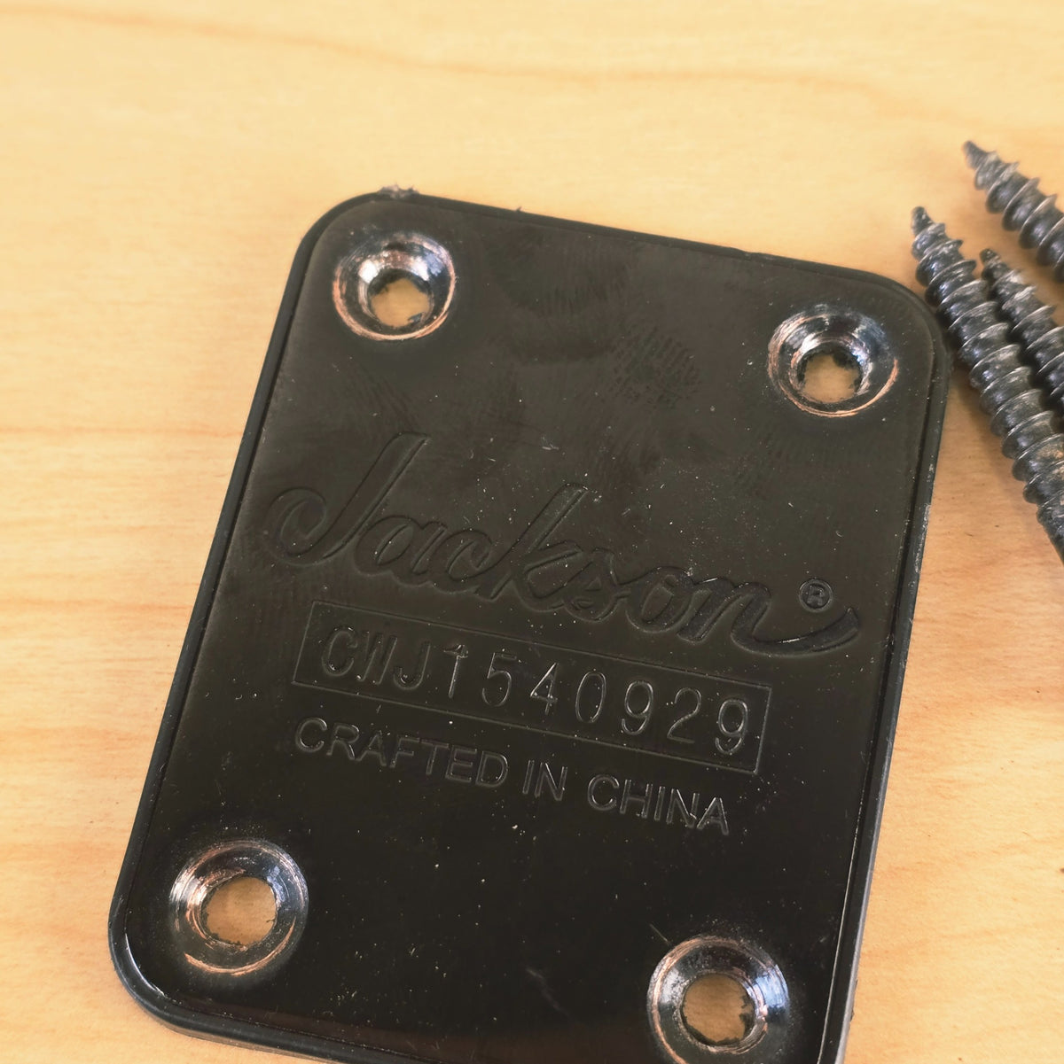 Close-up of Jackson black neck plate showing logo and serial number CWJ1540929