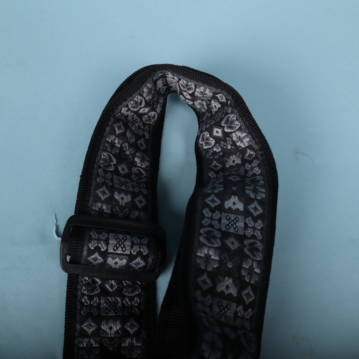 Upper folded loop of the strap showing the woven pattern and plastic hardware.