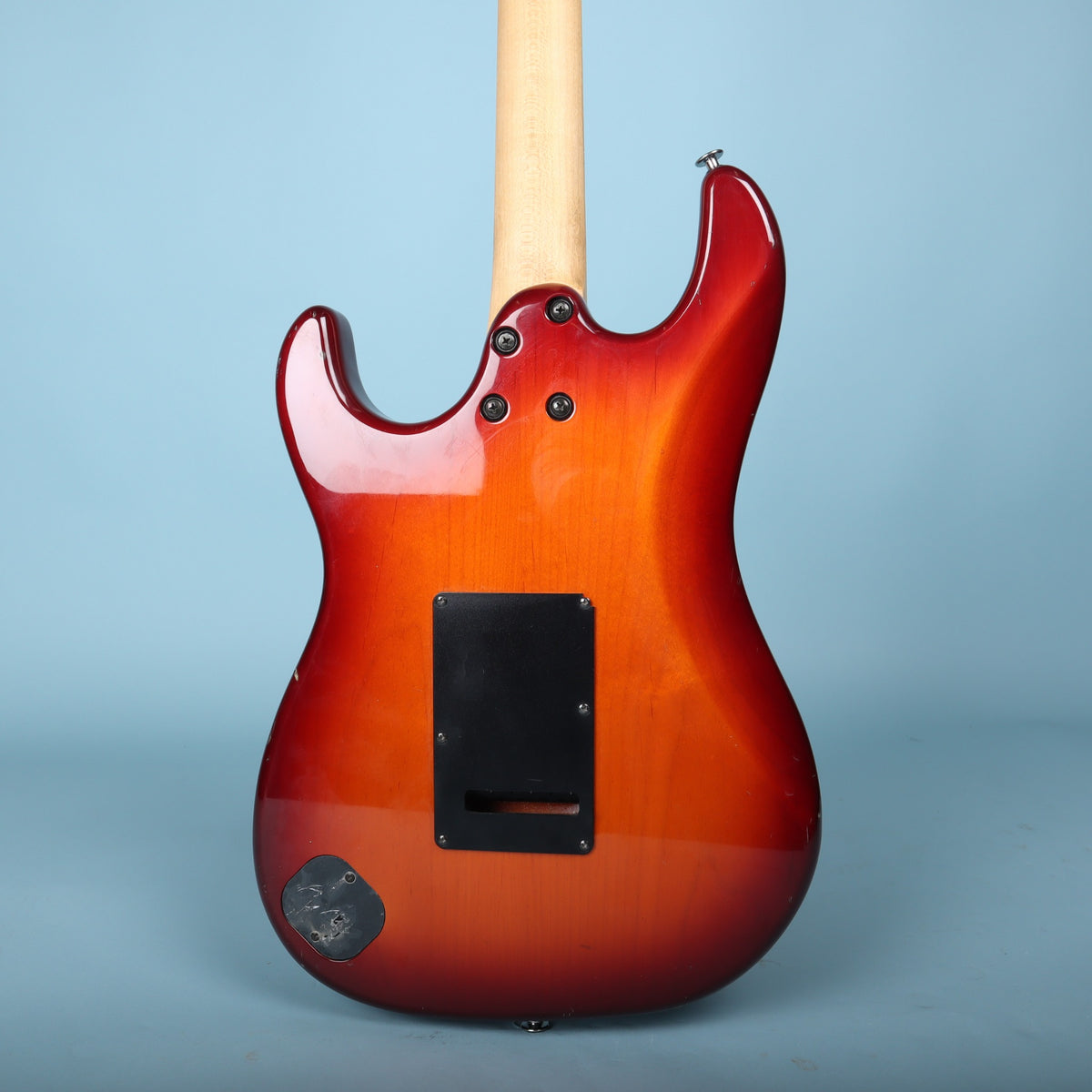 Rear view of red sunburst body showing contoured heel and tremolo cavity cover.