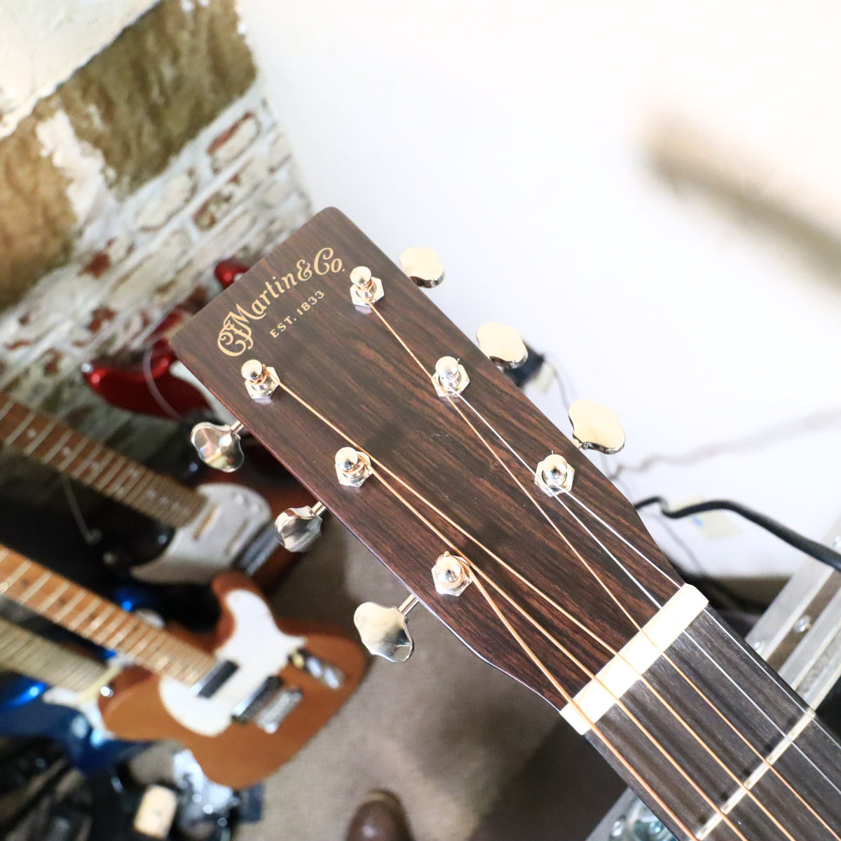 Martin 0-18 headstock angled view on a tech workbench.