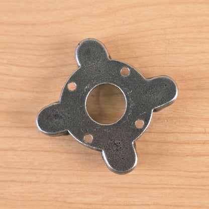 Flat back view of metal part on wood surface
