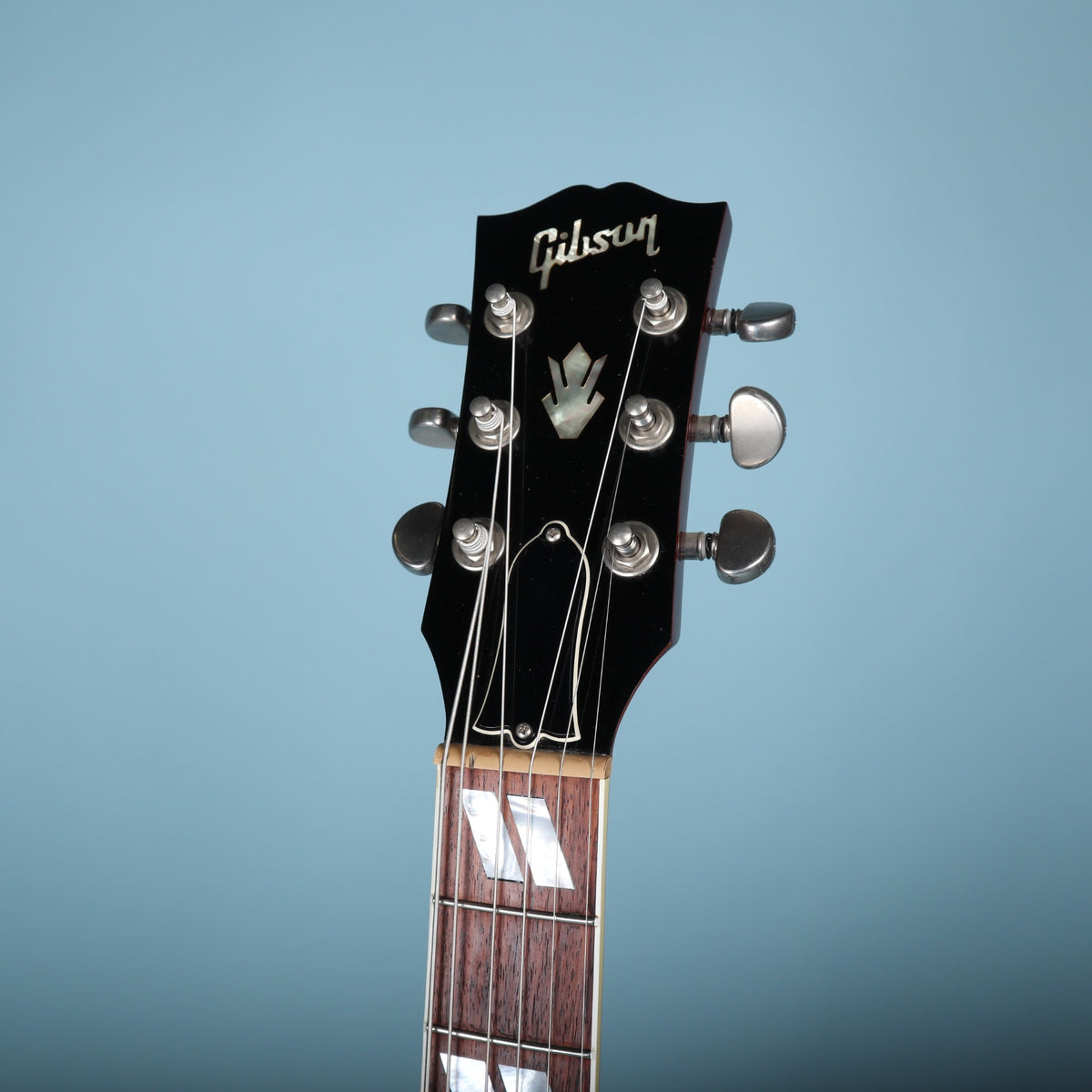 The headstock face featuring the Gibson logo, crown inlay, and truss rod cover.