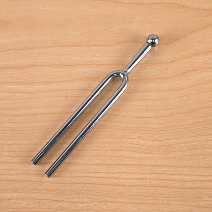 Full view of the A-440 Hz tuning fork resting on a wooden surface