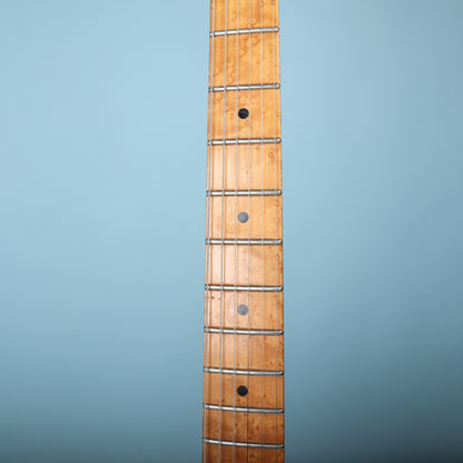 Close-up of maple fingerboard with black dot fret position markers.